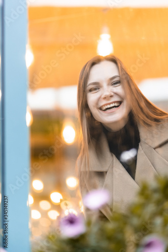 Obraz na płótnie Outdoor fashion portrait of stylish young woman having fun, emotional face , laughing, Urban city street style wearing dark casual trousers, white sweater,creamy coat. and sunglasses Fashion concept. w salonie