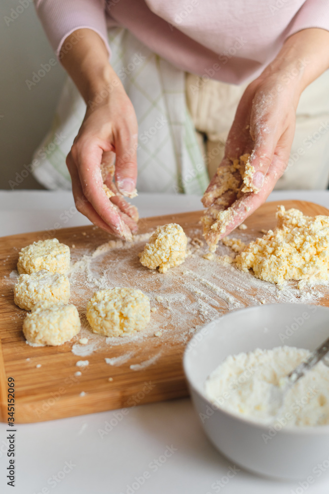 Woman making homemade cheese pancake for breakfast. Girls hands in flour. Cooking fresh healthy food. Preparation raw ingredients for baking. Chef kneading on kitchen table. Culinary work