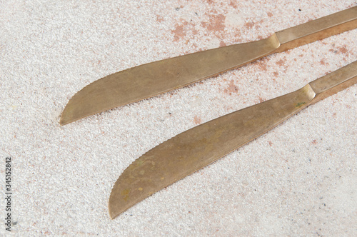 Two old bronze knives on concrete background. photo