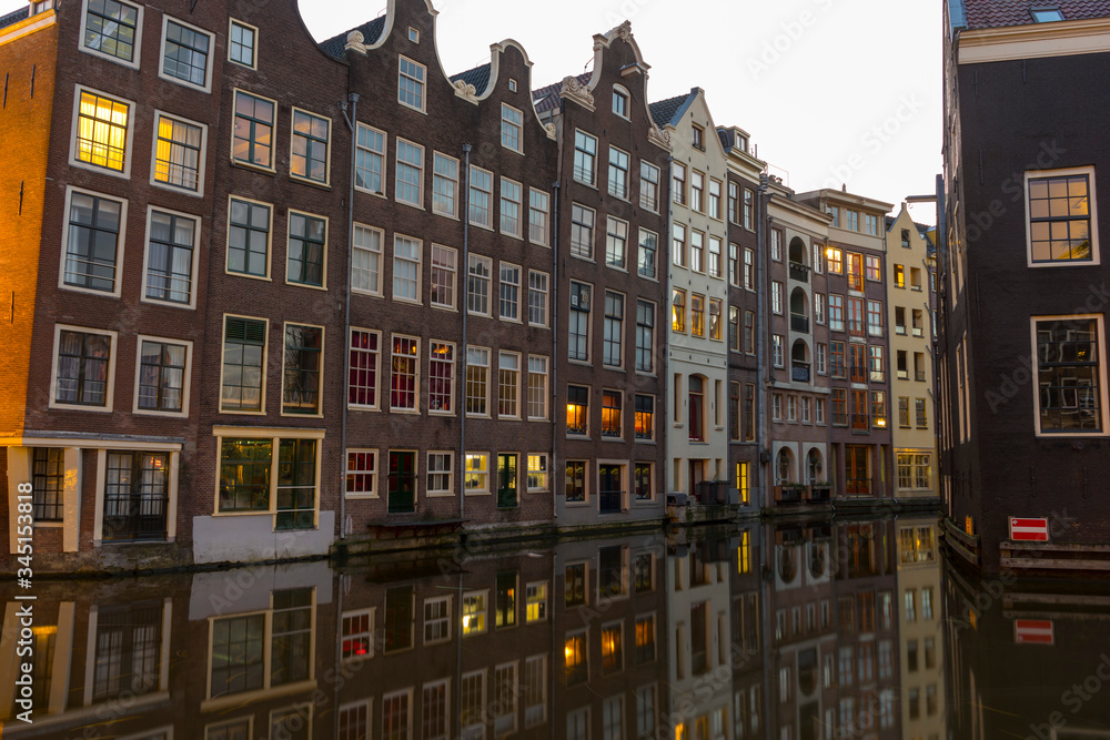 Obraz premium Famous dancing houses and buildings in Amsterdam with reflection in canal water.