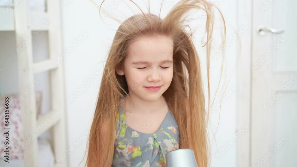 little girl drying her long hair with hair dryer little girl drying her long hair with hair dryer