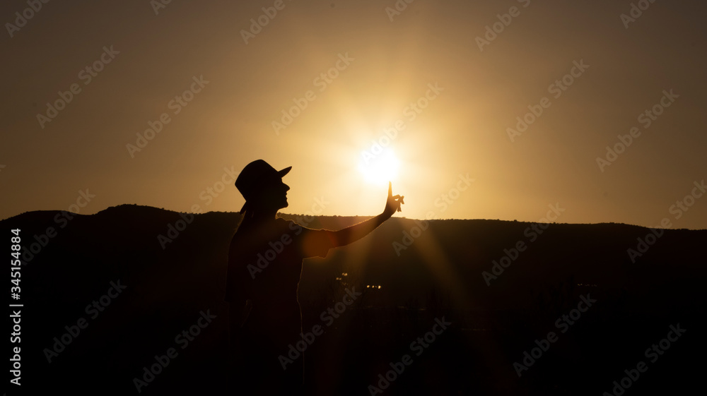 Silueta de mujer tocando el sol en el atardecer. Silueta de mujer tocando el sol en el atardecer.