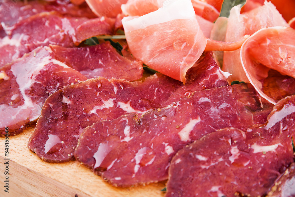 Assorted meat on a wooden board on a white background. Horizontal photo Assorted meat on a wooden board on a white background. Horizontal photo