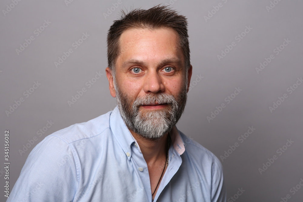 Portrait of a middle-aged man with a beard, smiling and looking at the camera Portrait of a middle-aged man with a beard, smiling and looking at the camera