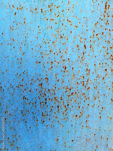 Blue background with small dots of rust.