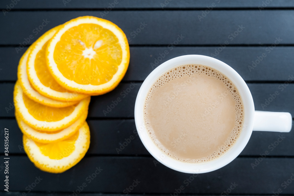 Coffee with milk and orange slices on black background top view. Vegan Breakfast. Healthy food. Orange coffee Raf. Coffee with milk and orange slices on black background top view. Vegan Breakfast. Healthy food. Orange coffee Raf.