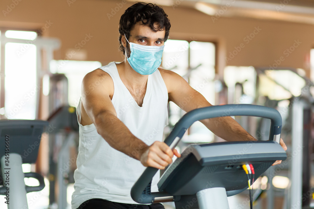 Man in the gym, exercising his legs doing cardio training on bicycle