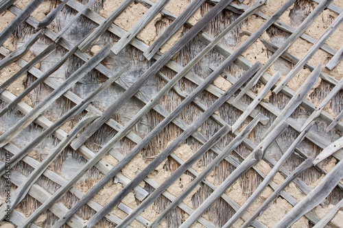 Wall With Wooden Mesh. Smeared With Rough Mortar. The Fence Of A Wooden Is Covered With Pottery Clay, Old Ceiling Made Of Dry Plaster On A Wooden Lattice