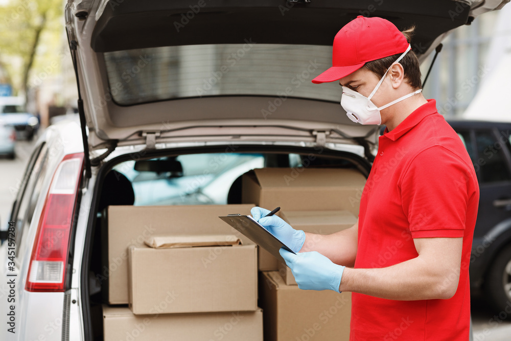 Delivery man near car with open trunk with parcels Delivery man near car with open trunk with parcels