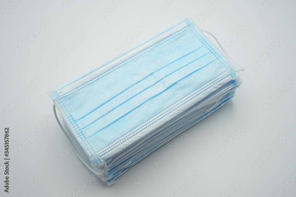 A pile of blue disposable surgical mouth masks 