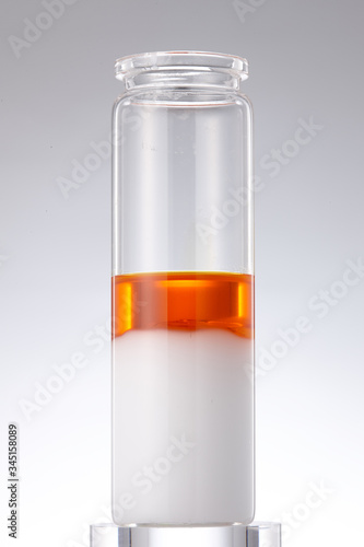 a glass bottle with layers of hardened oil and liquid oil.