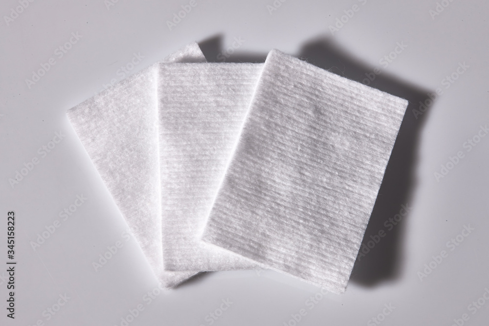 Fototapeta premium Three square cotton pads with white background.