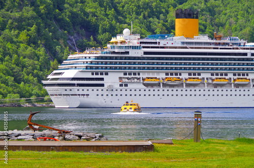 Big Italian Costa Cruises cruiseship or cruise ship liner Costa Favolosa in Geirangerfjord in Geiranger, Norway during Fjord cruising with landscape and natural scenery photo