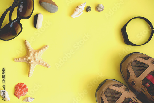  sport woman accessories on yellow background. Summer flat lay with copy space for text or advertising. sneackers, sunglasses and spotr tracker for summer sale. copy space for text