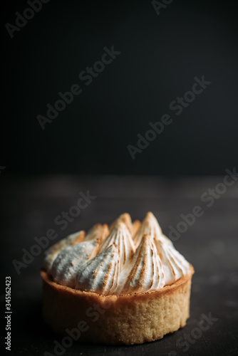 Creamy cake decorated with meringue cream on the rustic background. Selective focus. Shallow depth of field.