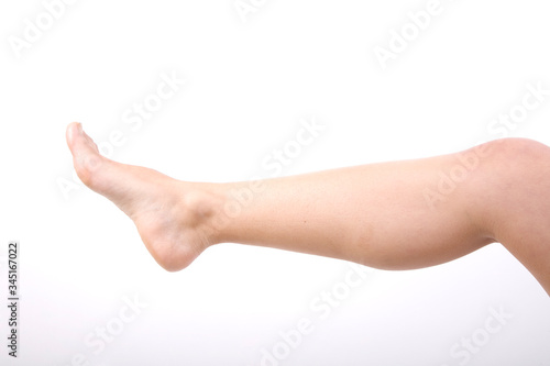 Leg of young woman on light background 
