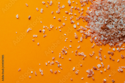Himalayan pink salt pilel on orange background. Crystal salt.