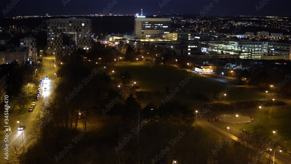 A cityscape with a road and an illuminated park at night - top view