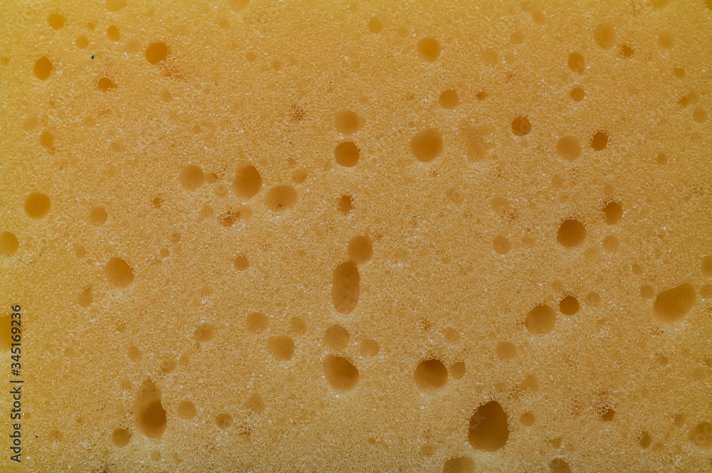 Texture of a yellow foam sponge with holes Texture of a yellow foam sponge with holes