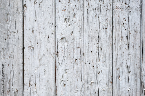 Old wooden boards painted by white paint. Narrow planks with scratches and cracks top view. Gray wooden background, old wood texture.