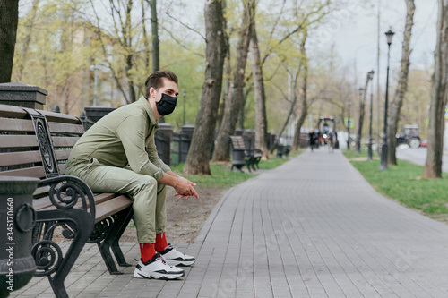 A man in a protective mask sits on a bench © Кристина Павлова