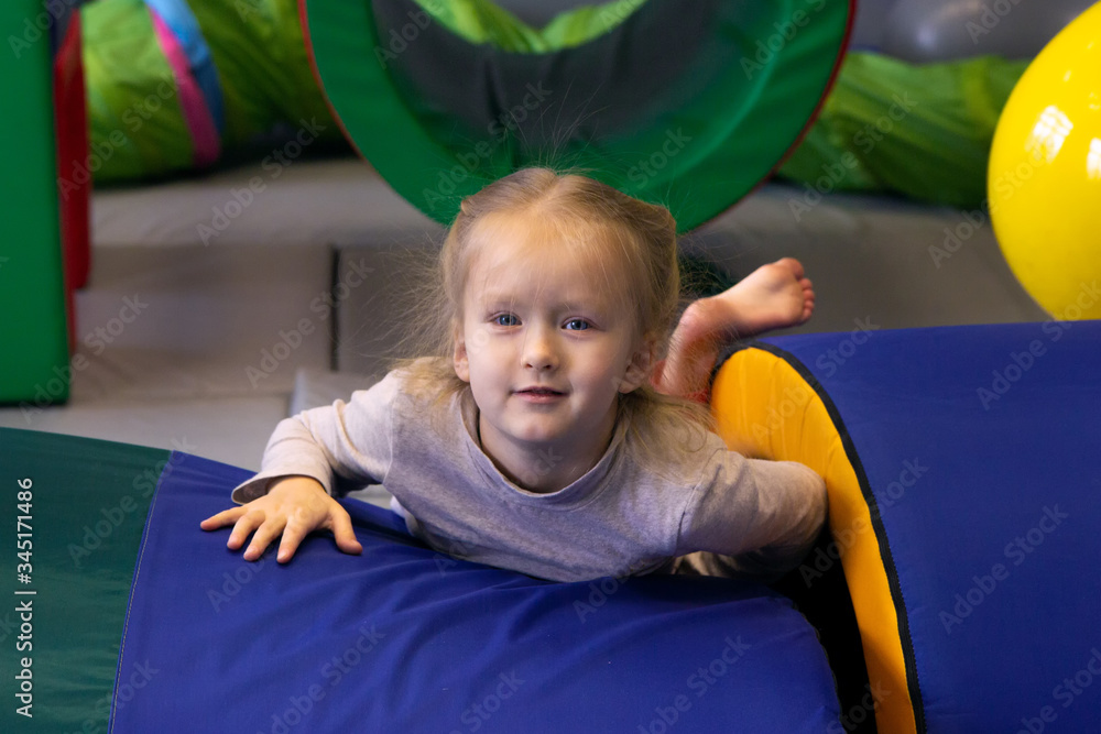 Smiling girl lies on the mat in gym sensory integration Smiling girl lies on the mat in gym sensory integration