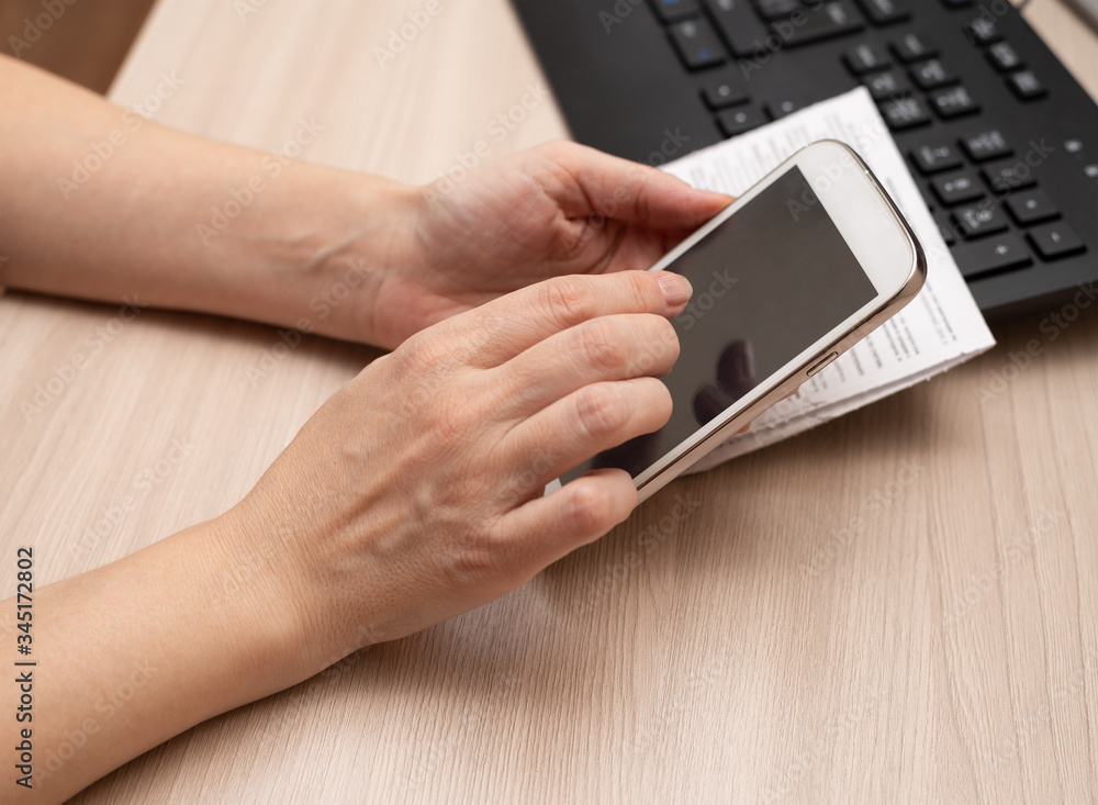 pay bills via white phone, hands closeup, on touch screen pay bills via white phone, hands closeup, on touch screen