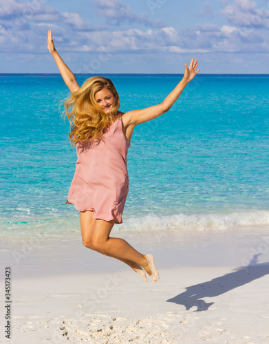 Beautiful woman in a jump on the beach. Young woman in a short dress  on the beach. Blonde in a swimsuit. Woman on the beach.