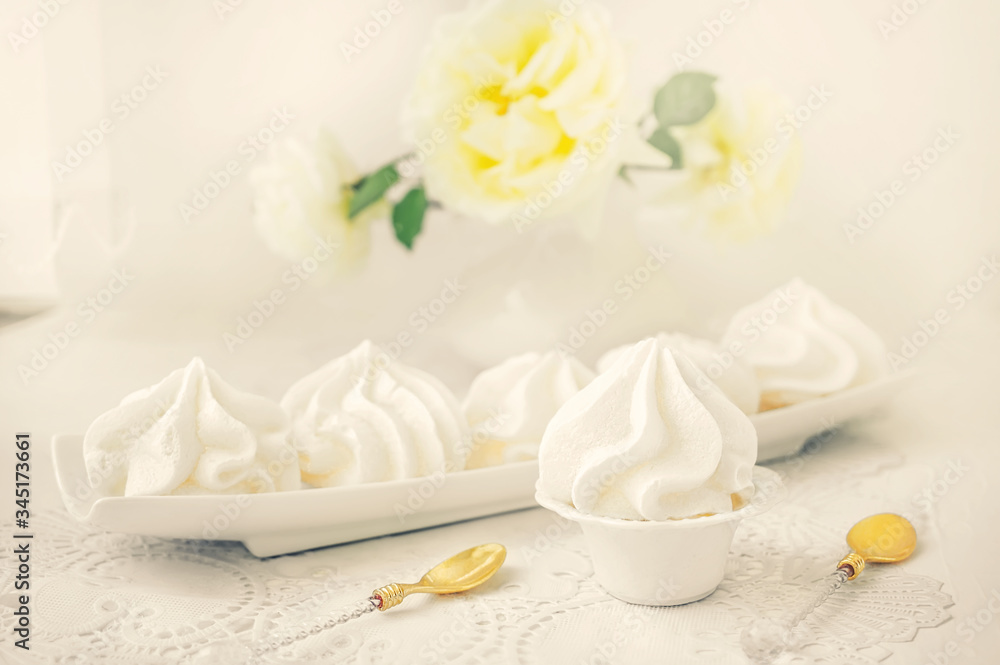 White handmade meringue on a white plate is served in an elegant style. Homemade cake