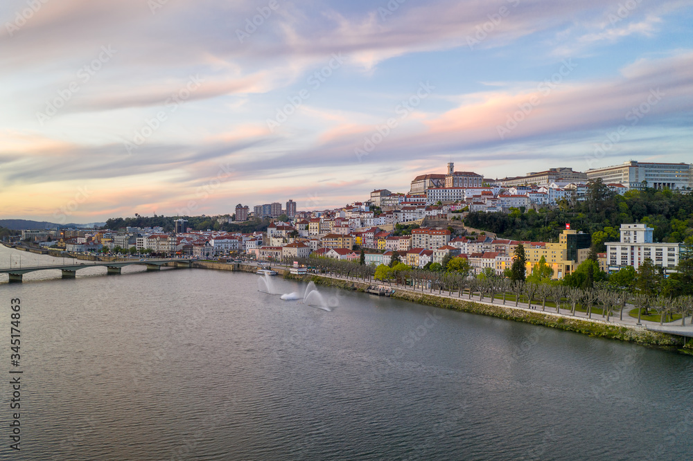 Coimbra drone aerial city view at sunset with Mondego river and beautiful historic buildings, in Portugal