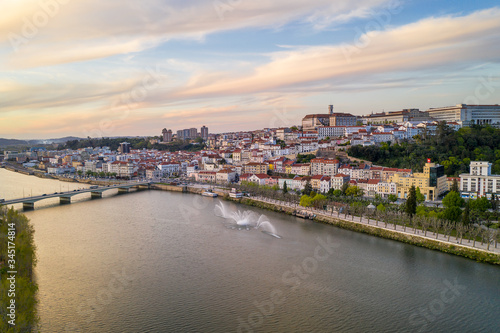 Coimbra drone aerial city view at sunset with Mondego river and beautiful historic buildings, in Portugal © Luis