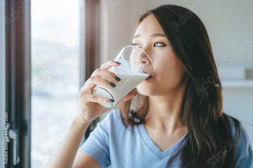Fotografía Close up view of asian woman drinking milk.