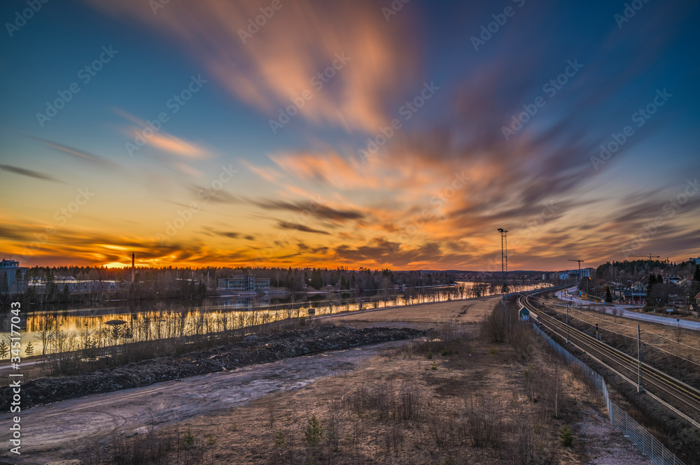 Fototapeta premium The scenic view of passing cloud during the evening sunset with cityscape adventure in nordic country