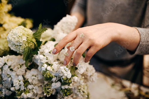 Close-up of female florist hands making bouquet in flower shop.