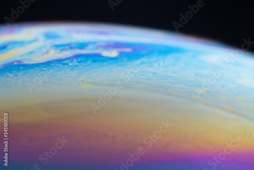 abstract background iridescent paint, colors iridescent interference rainbow on a soap bubble. The rounded surface of the sphere