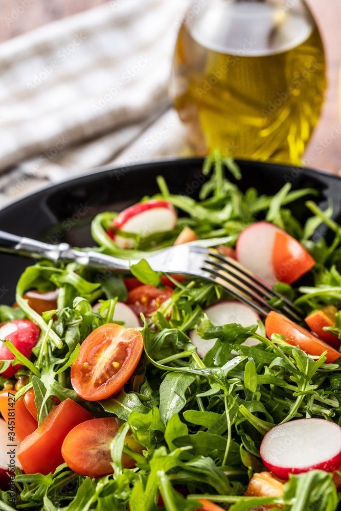 Fresh arugula salad with radishes, tomatoes and red peppers. Fresh arugula salad with radishes, tomatoes and red peppers.