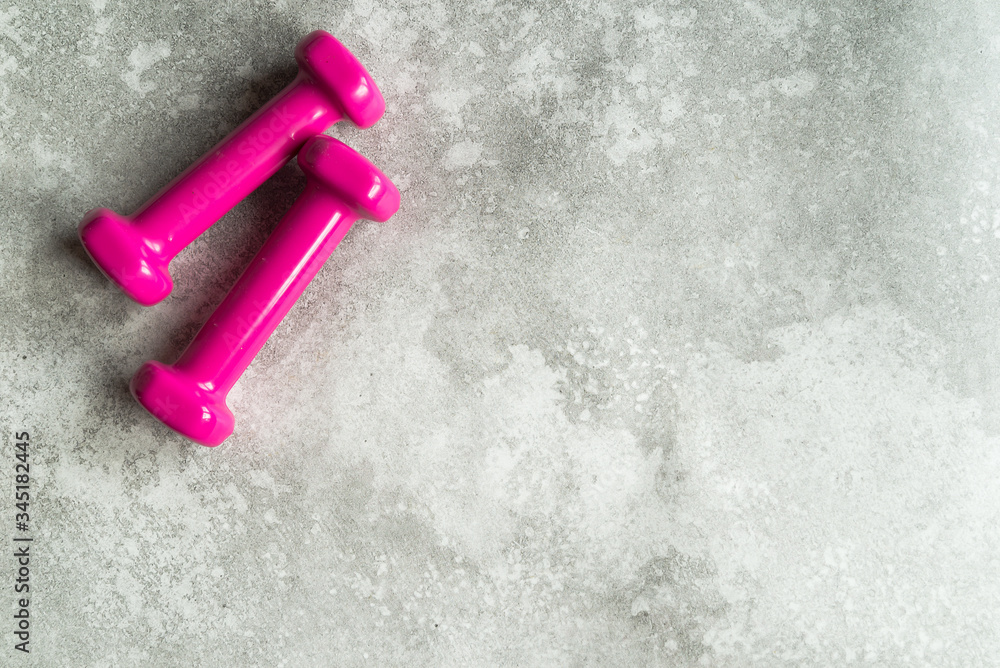pink dumbbels on grey background, top view pink dumbbels on grey background, top view