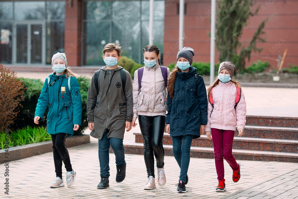 Children students in medical masks leave the school. Children students in medical masks leave the school.