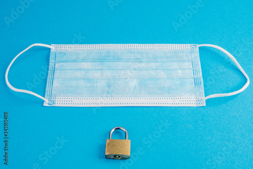 Canvas Print Disposable paper face mask with padlock on blue
