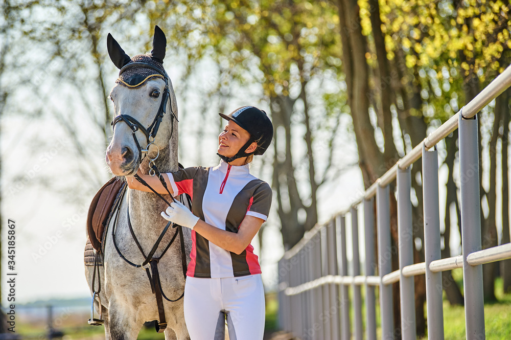 Obraz premium Girl horse rider stroking a horse. Equestrian theme