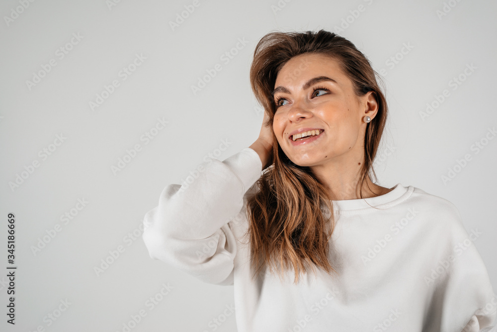 Happy excited woman looking to the side with wind in the hair on white background Happy excited woman looking to the side with wind in the hair on white background