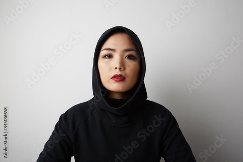 Close-up portrait of a young adult Malaysian woman wearing traditional head scarf hijab. Space for text.