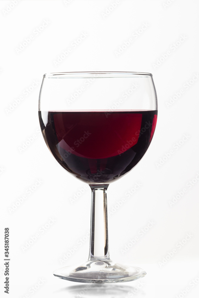 Side view of a glass glass of red wine on a white isolated background. Concept of wine preparation and tasting
