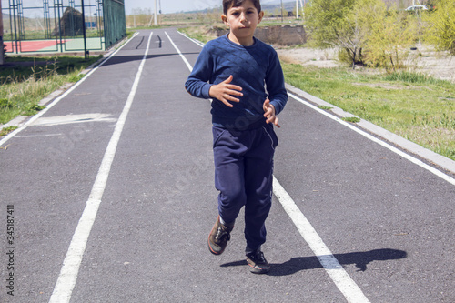 young boy runs on a track