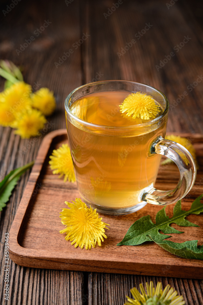 Herbal drink for liver detox, dandelion root tea in a glass cup decorated with fresh flowers Herbal drink for liver detox, dandelion root tea in a glass cup decorated with fresh flowers