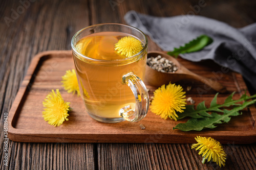 Herbal drink for liver detox, dandelion root tea in a glass cup decorated with fresh flowers