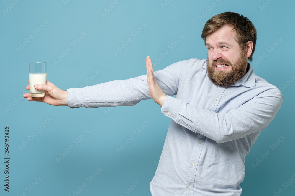 Lactose intolerance. Dairy intolerant man making a stop gesture glass of milk, which is holding in hand. Lactose intolerance. Dairy intolerant man making a stop gesture glass of milk, which is holding in hand.