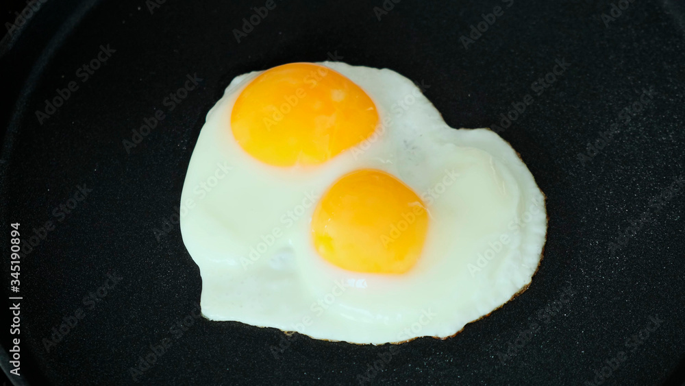 Cooking Fried eggs in pan on stove. Close up. Cooking Fried eggs in pan on stove. Close up.