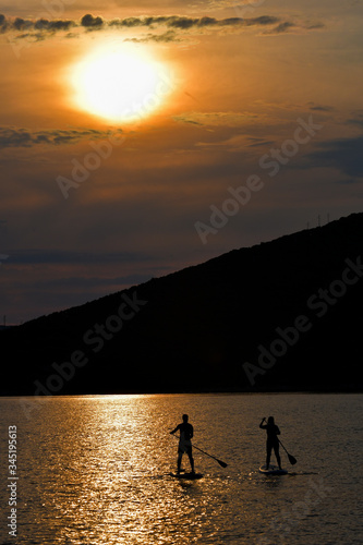 Sup boarding couple on sunset