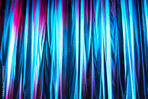 Blue and purple lit with different colours texture of a textile theatre curtain during the presentation. Texture template and mockup.